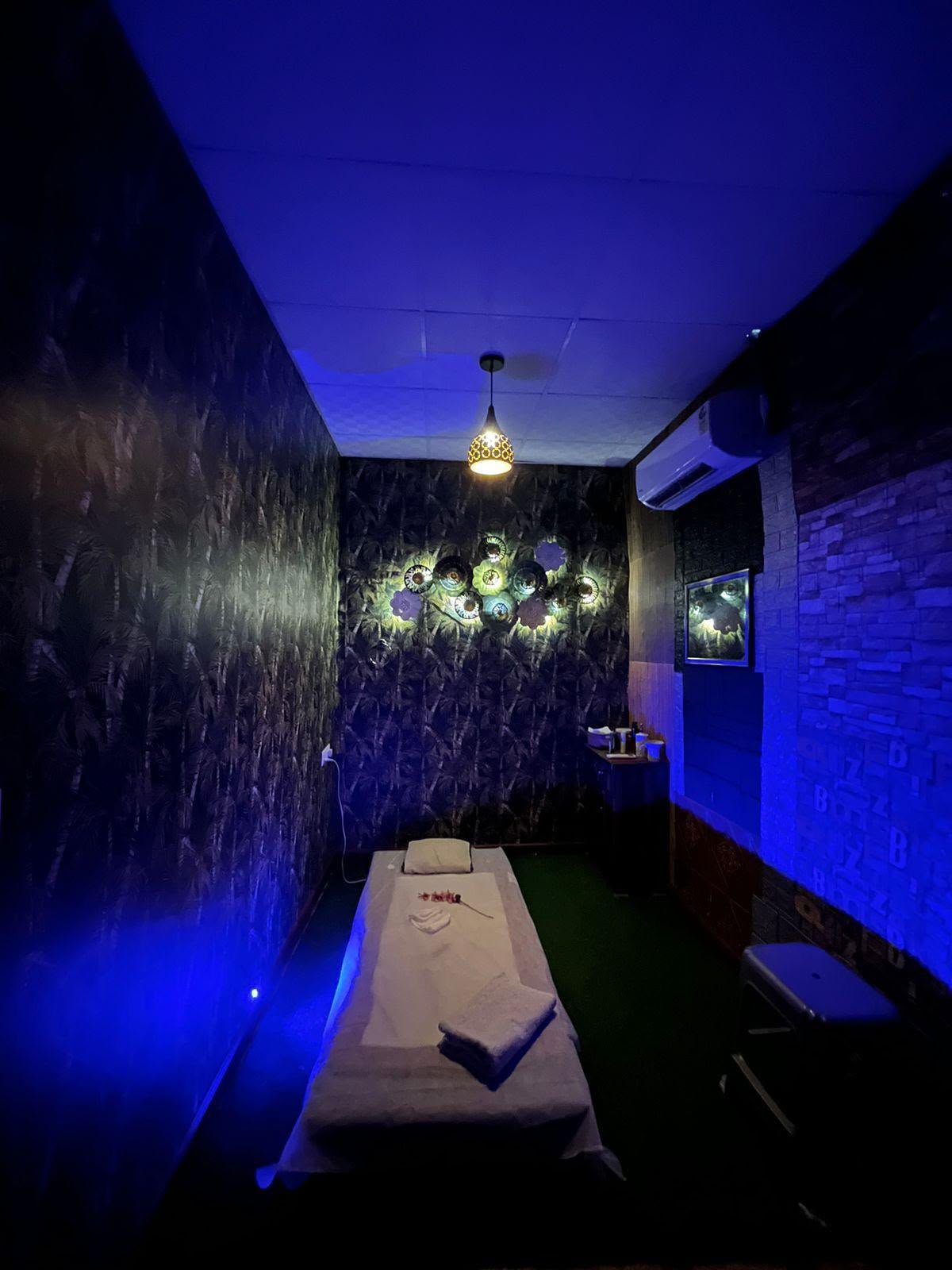 Single treatment room bathed in dramatic deep blue LED light — the most editorial suite at Lavella Wellness