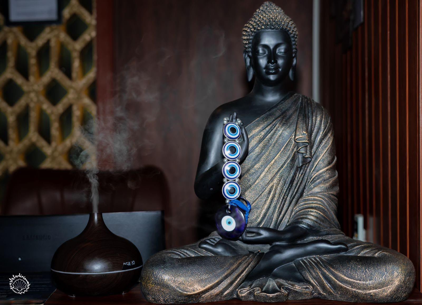 Black bronze Buddha statue with evil eye charm and diffuser mist — the soul of Lavella Wellness