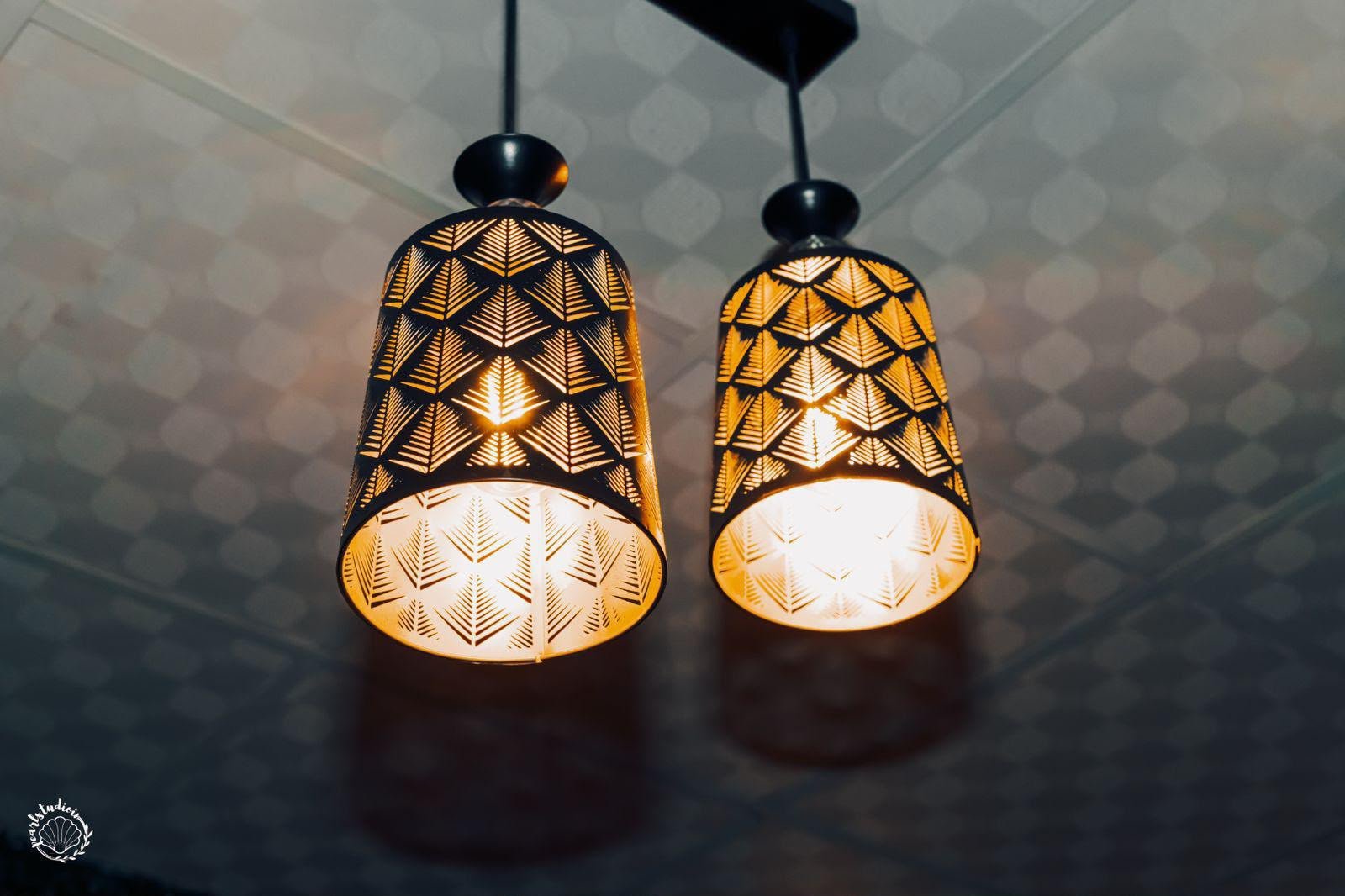 Artisan geometric pendant lamps casting warm gold patterns — the signature glow of Lavella Wellness