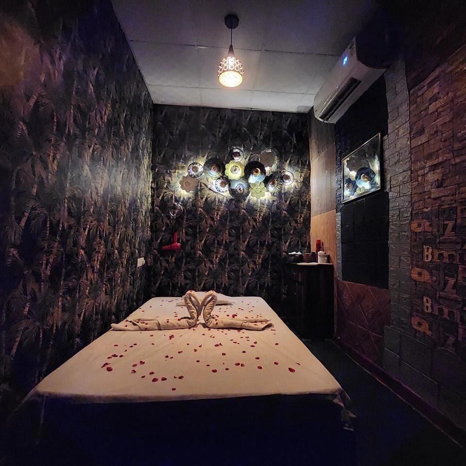 Lavella Wellness single suite at night — dark tropical botanical wallpaper, towel swans, rose petal heart and artisan wall art