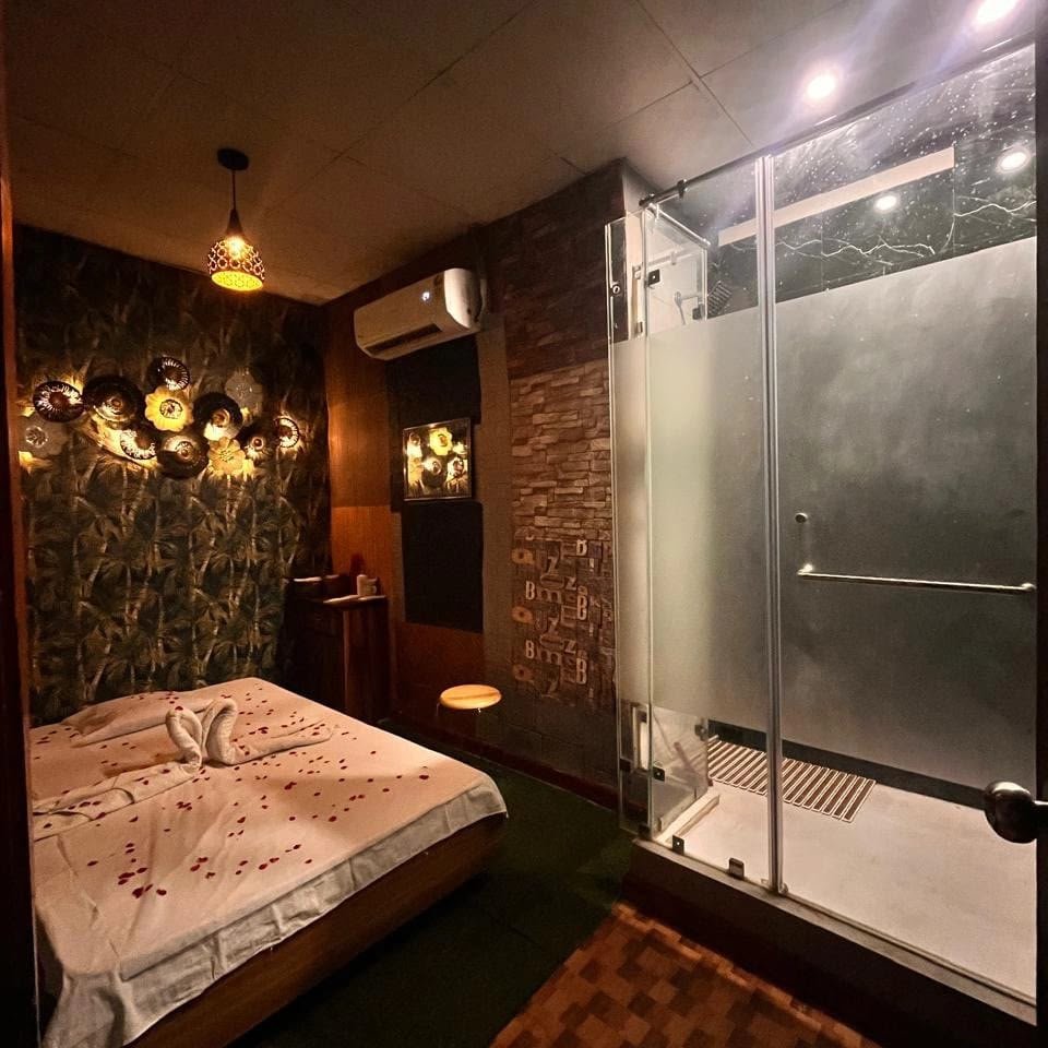 Private suite at Lavella Wellness — warm botanical ambiance, rose petals and en-suite shower
